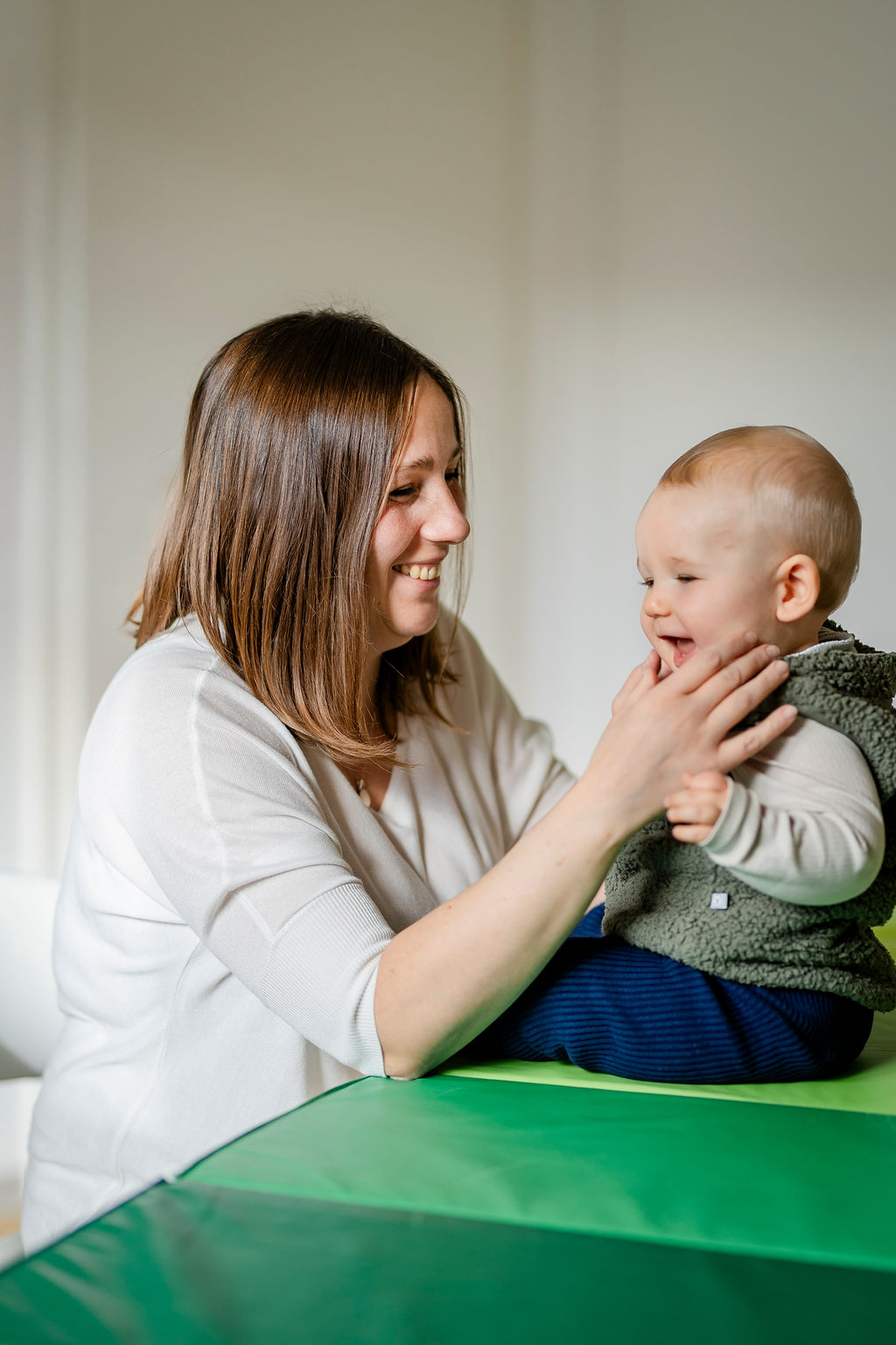 Logopädin spielt mit einem Baby während der Therapie